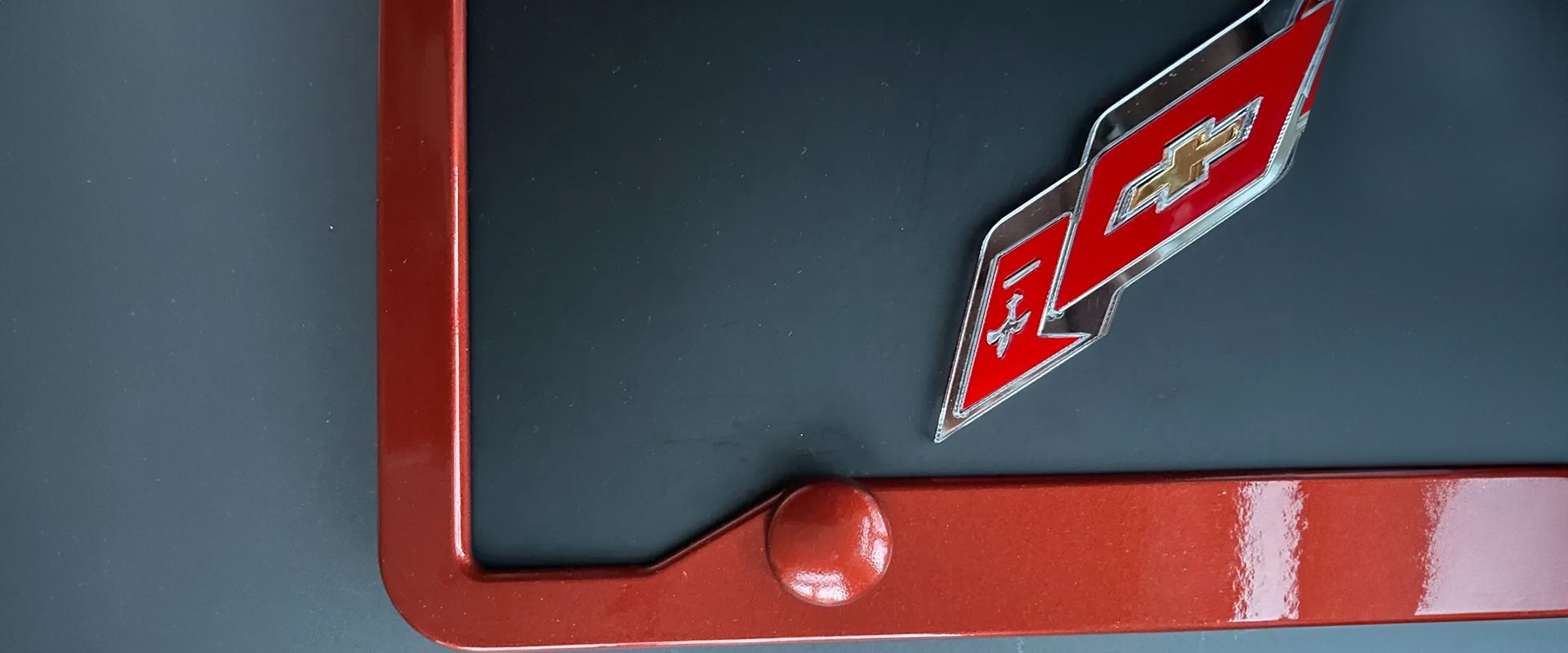 Close-up of a red billiard ball resting on a pool table corner.