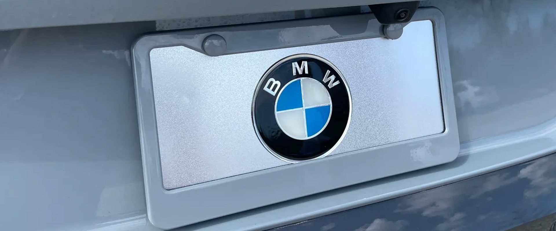 Close-up of a BMW logo on a silver car.